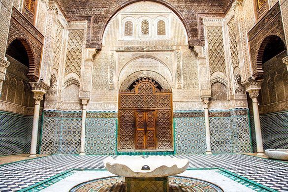 Al-Attarine Madrasa in Fès showcasing intricate Moroccan tilework, carved wood, and serene courtyard – luxury cultural exploration with Morocco Luxury Highlights