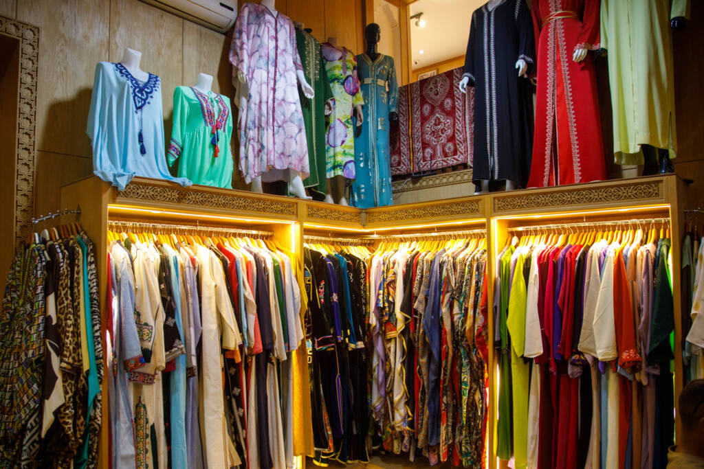 Private luxury guide accompanying a client in a high-end kaftan boutique in Marrakech.