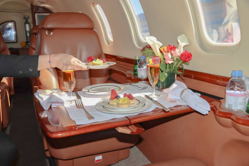 Luxury Learjet interior with dining table set for in-flight lunch, private jet experience by Morocco Luxury Highlights