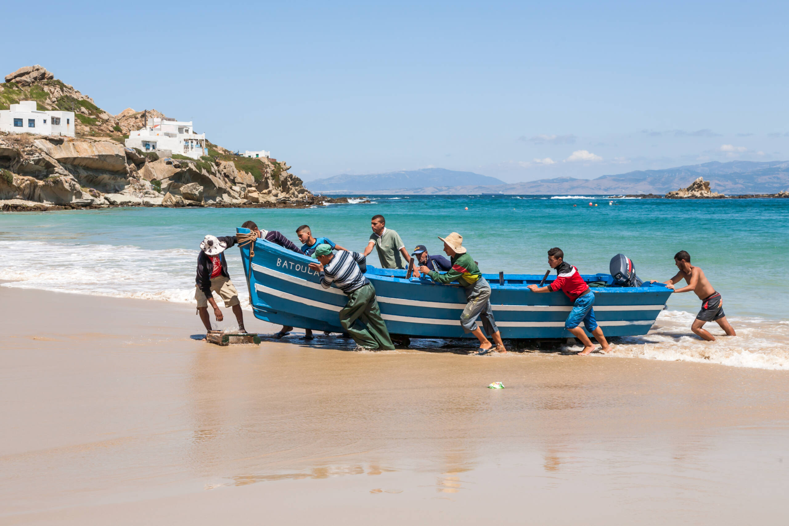 JUNE 8.2014-TANGIER, MOROCCO: In the picture we can see how a fishing boat to the beach and other men is help put the boat in the sand