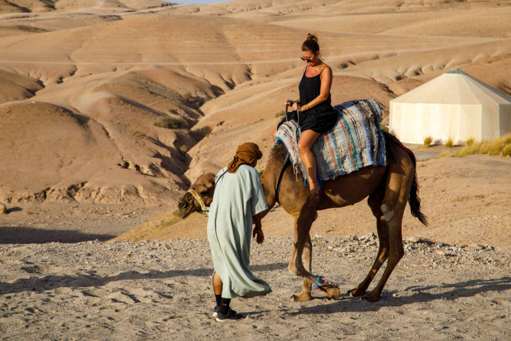 Desert landscape in Morocco at sunset with golden dunes and luxury camp, illustrating the best Morocco trip packages from the US with guided tours, private experiences, and exclusive desert adventures.
