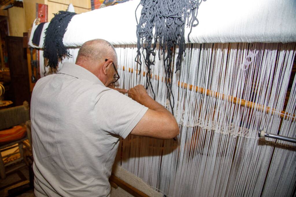 Moroccan women weaving handmade rugs in a traditional Atlas Mountains cooperative workshop